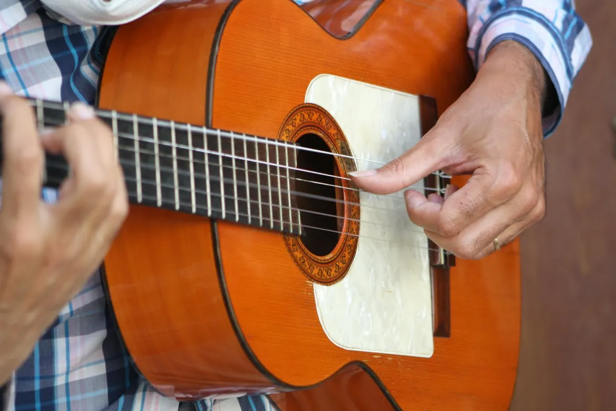 Nærbilde av hender som spiller klassisk gitar app